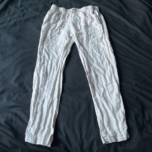 Vita linnebyxor  - Luftiga vita linnebyxor. Raka ben och avslappnad passform. Byxorna har fickor på sidorna och är tillverkade i ett svalt linnematerial.