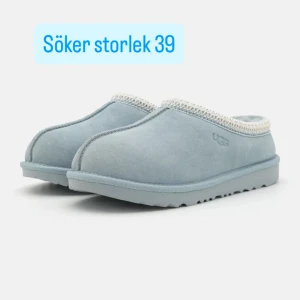 SÖKER Ljusblå slip-in skor från UGG - SÖKER I STORLEK 39. Mysiga ljusblå slip-in skor från UGG i mocka med mjuk kantdetalj upptill. Skorna har en platt sula och rund tå, perfekta för chill dagar hemma eller när du vill ha det extra bekvämt.