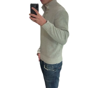 Beige stickad tröja med knappar - Snygg beige stickad tröja med ribbad krage och tre knappar vid halsen. Tröjan har långa ärmar och ribbade muddar vid ärmslut och nederkant. Perfekt för dig som gillar en clean och stilren look.