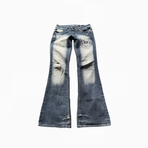 Crazyage jeans - Sjukt snygga crazy age jeans med röda detaljer, de är i jättebra skick inga stenar eller något saknas!🪽💋 Storleks lappen är avklippt så gå efter mått men skulle säga att de är 34/36. <3 Midjemått = 38cm  innerbenslängd= 82cm lår= 21cm ! 