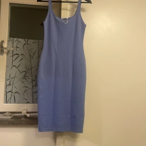 Ljusblå långklänning från Zara - Säljer en stilren ljusblå hlavlångklänning från Zara med smala axelband och rundad halsringning. Klänningen har en rak passform och en liten slits baktill för extra rörelsefrihet. Materialet är mjukt och stretchigt, perfekt för en clean och modern look. Klänningen passar dig med storlek S.