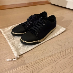 Lanvins i marin blå - Lanvin sneakers – skick 8/10 Äkta Lanvin sneakers i mörkblå canvas med svart tåparti. Klassisk och stilren modell. Lite slitage på sulan men i övrigt väldigt fräscha. Original dustbag ingår. Färgen och själva modellen e väldigt exklusiv och och är svårt att få tag på  Obs! Enbart dustbag följs med😯   Priset kan såklart diskuteras😎🍾  nypris runt 4 000–6 000 kr