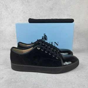 LANVIN DBB1 CAP TOE SNEAKER - – Condition: 9/10  - Size: 46/UK12  – What is included: Dustbag  – Retail price: 5500 + SEK  Please note that Lanvins fit big and our recommendation is to go one size down