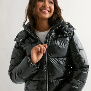 Svart glansig pufferjacka med huva - Säljer min Nelly populära Nelly jacka i storlek XS💞 Den är använd fåtal gånger och är så gott som ny i skicket! Pris går möjligen att diskutera