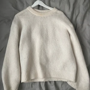 Vit stickad tröja med rund hals - Mysig vit stickad tröja med rund halsringning och ribbade muddar vid ärmslut och nederkant. Perfekt för lager-på-lager och passar till allt. Enkel och stilren design som funkar året runt.