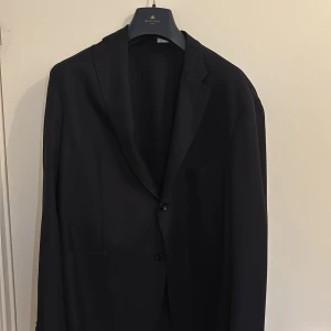 Svart kavaj från Boglioli Milano - Stilren svart kavaj från Boglioli Milano med klassisk passform. . Tunt fodrad och tillverkad i ett elegant tyg som ger en exklusiv känsla. Nypris ca 10 tusen.