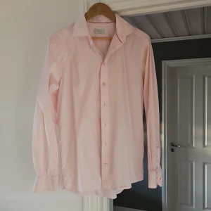 Ljusrosa skjorta från Eton - Snygg ljusrosa skjorta från Eton i klassisk modell med lång ärm och knappar framtill. Skjortan har en stilren contemporary fit och är tillverkad i mjuk bomull. Perfekt för dig som gillar en clean och fräsch look.