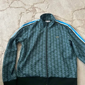 Grön mönstrad vindjacka från Lacoste - Lacoste monogram tröja i storlek L, knappt använd