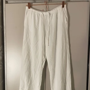 Vita linnebyxor med snörning - Säljer ett par fräscha vita linnebyxor med avslappnad passform och elastisk midja med snörning. Perfekta för varma dagar och chill vibes. Lätta och luftiga, passar till sneakers eller sandaler. Dom är i super fint skick, från Gina tricot i storlek S.