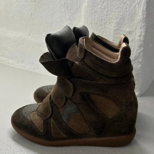 Bruna Isabel Marant Étoile sneakers - Bruna/mörkgröna sneakers från Isabel Marant Étoile. Äkta! köpta via Vestiare Collective, de är flitigt använda och har små tecken på användning därav säljer till ett lite lägre pris! Så snygga höstskor både till vardags eller vid festligare tillfälle🫶🏼😍