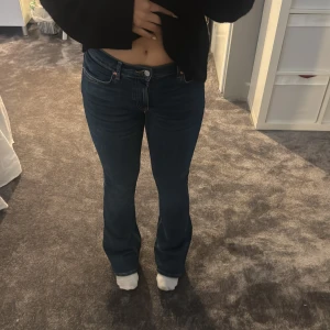 Blå bootcut jeans midwaist - Snygga blå jeans med bootcut passform och midwaist. Jeansen har klassisk femficksdesign och är tillverkade i ett stretchigt denimtyg som sitter skönt. Perfekta för dig som gillar en tidlös look med lite utsvängda ben.