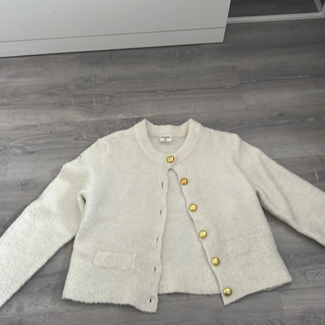Vit kofta  med guldknappar