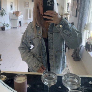 jeansjacka från Zara - Säljer en ljusblå jeansjacka från Zara. Har en väldigt stilren look och passar till mer eleganta men även vardagliga evenemang, strlk xs men passar om man har s med