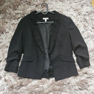 Kavaj med korta armar - Strl 44 från H&M med axelvaddar. 