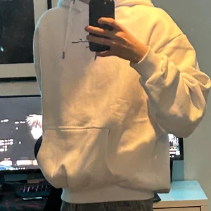 Vit hoodie från Karl Kani XL - Vit hoodie från Karl Kano i storlek XL med coolt tryck i blått, rött och gult på ryggen och svart broderad logga framtill. Sjukt bra passform och passar L lika väl. Knappt använd över huvud taget.    Frågor om produkt eller pris? Bara att höra av sig!