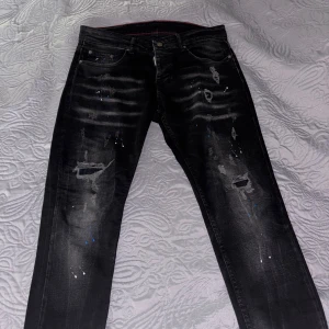 Svarta dsquared2 jeans - Säljer ett par svarta dsquared2 jeans dem är i storlek 46 i dsquared storlekar vilket skulle passa folk med läng 32 kan passa folk som har 34 också. Dem är helt svarta inte så mycket mönster nästan helt nya. Frågor om storlekar det är bara att skriva 😀