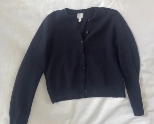 Mörkblå kofta från H&M - Mysig mörkblå kofta från H&M med rund hals och knappar. Långärmad, mjuk och skön! 💕Jag har ofta S/XS men köpte L för att den ska sitta som på bilden❤️