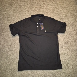 Svart pikétröja från Polo Ralph Lauren. - Svart pikétröja från Polo Ralph Lauren. Toppskick aldrig använt. 