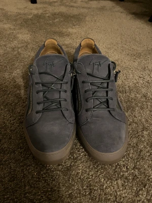 Blå  Giuseppe Zanotti - Snygga mörkblå sneakers från Giuseppe Zanotti i mocka. Säljer dessa då jag har använt dem max 2 gånger på 1 år. Skick 10/10 som nya inte en defekt. Har påsen, lådan och kvitto om mer bilder behövs så är det bara att höra av sig.