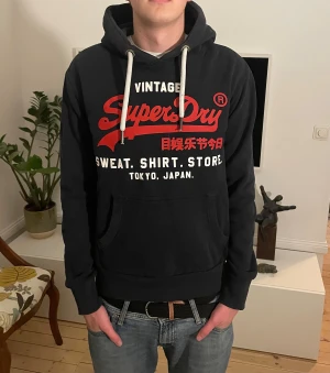 Svart Superdry hoodie  - Snygg superdry hoodie i Storlek S. Modellen är 187cm. Hör av dig vid minsta fundering