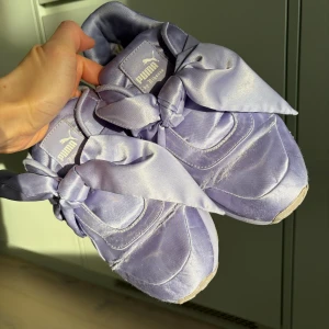 FENTY x PUMA by Rihanna sneakers - Säljer ett par FENTY x PUMA by Rihanna sneakers i lila med sidenliknande material.
 Skorna är original PUMA och i storlek 38.
 Skorna är välanvända och har synligt slitage (se bilder), särskilt på tygytan, men de fungerar fortfarande bra för dig som gillar modellen eller vill ha dem som samlarobjekt/idle item.
 Ett ovanligt och stilsäkert par skor från en eftertraktad kollektion — perfekt för dig som vill ha något unikt.
 Tillgänglig för upphämtning i Kista, Stockholm, eller leverans.
