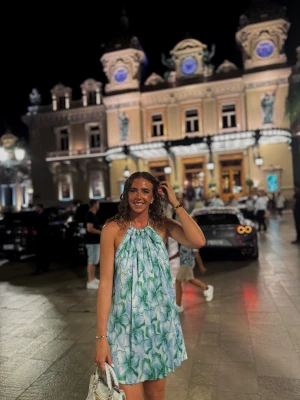 Blommig kortklänning med öppen rygg - Säljer en superfin kortklänning med blommigt mönster i blått, grönt och vitt. Klänningen har halterneck med knyt i nacken och en snygg öppen rygg. Materialet är lätt och flowy, perfekt för varma dagar. Passformen är loose och klänningen har en avslappnad vibe.