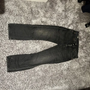 Svart/gråa Levis 501 jeans - Säljer ett par klassiska svarta Levis 501 jeans. De har en straight passform och knappar i gylfen. Perfekta för en stilren look. Nypris: 1200 kr