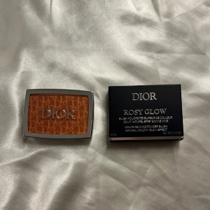 Dior Rosy Glow Rouge (012 ROSEWOOD) - Dior Rosy Glow rouge i puderform med lyxig silverfärgad dosa och spegel. Färgen är en varm rosig nyans med Dior-logga präglad i pudret. Kommer med originalförpackning helt oanvänd 
