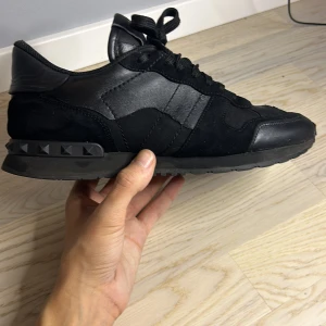 Valentino rockrunners - Tja säljer ett par feta valentino rockrunners i enligt mig den fetaste och bästa färgen, svart och bästa modellen. Storlek 43 men passar även 44. Självklart autentisk, för er som är skeptiska ändå så finns köparskyddet där för att skydda är vid fakes osv. De är i 6/10 skick om de inte var för defekten i hälen o tån men enligt mig spelar de inte så stor roll då de inte ändrar hur skon sitter eller hur den ser ut, kom gärna med bud och frågor om mer bilder😊 och va snabba då dessa kan sälja snabbt