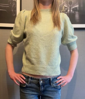 Ljusgrön stickad tröja med puffärm - Superfin ljusgrön stickad tröja med puffiga ärmar och ribbade muddar. Tröjan har en rund halsringning💚