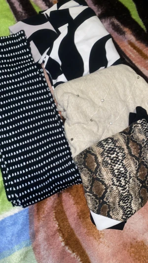 Fyra trendiga kjolar i olika mönster - Säljer fyra olika kläder : en svartvit med grafiskt mönster, en svart med vita ränder, en beige quiltad med pärldetaljer och en med snyggt ormmönster i brunt och beige. Perfekt för dig som gillar att mixa stilar och sticka ut med coola prints och detaljer.