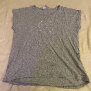 T-Shirt - Michael kors  - Säljer en grå T-shirt från Michael Kors i storlek M. Använd ett fåtal gånger och är i mycket bra skick.🩷