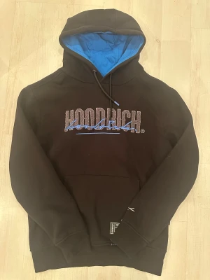 Svart Hoodrich hoodie med blåa detaljer. - Den är storlek medium och har varit använd 1-3 gånger.