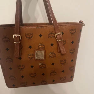  handväska  - Säljer en handväska med klassiskt logomönster och guldfärgade detaljer. Väskan är i helt ny skick pris kan diskuteras 🥰kan tänka mig gå ner i pris 