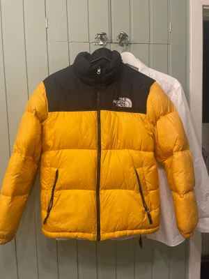 Gul och North Face puffer storlek XS/junior XL - Säljer en pufferjacket från The North Face som jag köpte för nått år sedan för 2800kr och nu säljer betydligt billigare. Jackan är i storlek XL Youth sitter som en XS skulle jag säga. kan skicka måtten om det skulle behövas jackan användes ungefär två säsonger och har lite smuts fläckar som säkert går att få bort hör av er vid funderingar