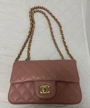 Rosa quiltad axelväska  - Säljer en lyxig rosa axelväska. Väskan har den ikoniska CC-loggan i guld på framsidan och är tillverkad i mjukt skinn. Perfekt för dig som vill ha en elegant och tidlös accessoar.