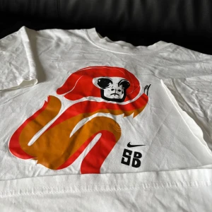 Nike SB T-shirt - Nike SB t-shirt i vitt med snyggt motiv på framsidan. Tjockt material och väldigt bra skick, i princip oanvänd. Funkar utmärkt som både skate och vardagstischa!