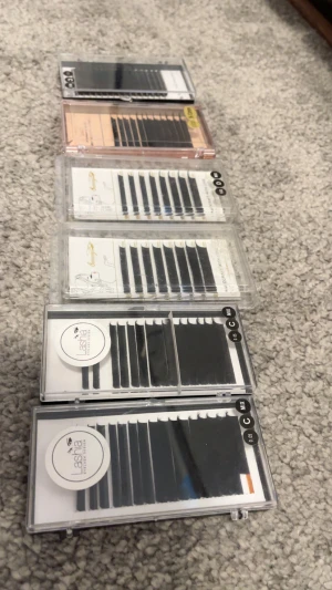 Mixade volymfransar från Lashia & Sunny - Säljer flera askar med svarta volymfransar i olika längder (8-15mm) och böj (C). Märkena är Lashia och Sunny, perfekta för fransförlängning. Fransarna kommer i praktiska plastaskar och är gjorda av syntetmaterial för en fyllig look.