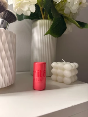 Jelly Stick Rouge från Smith & Cult - Superfin rouge i stickformat. Kommer i en snygg rosa plastförpackning och själva rougen har en geléliknande, bärig röd färg. Perfekt att svepa på kinderna för en fräsch look. Enkel att ta med i väskan tack vare smidig storlek. Den är testad typ två gånger. 