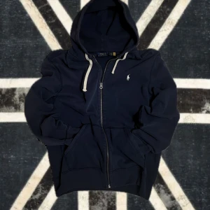 Polo Ralph Lauren Zip Hoodie (M) - Säljer en mörkblå zip-up hoodie från Polo Ralph Lauren i storlek M. Den är i princip ny, har bara använt den ett par gånger, så skicket är klockrent. Hör av dig om du är intresserad.
