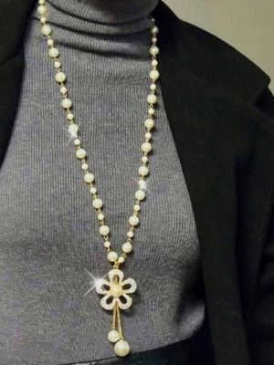 Långt glittrande pärlhalsband med blomma - .
