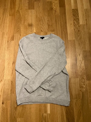 Grå Sweathsirt, Storlek M - Helt ny Tröja från H&M. Storlek M aldrig använd. Enkel tröja som passar till alla tillfällen. Hör av vid intresse/funderingar. PRIS KAN DISKUTERAS!
