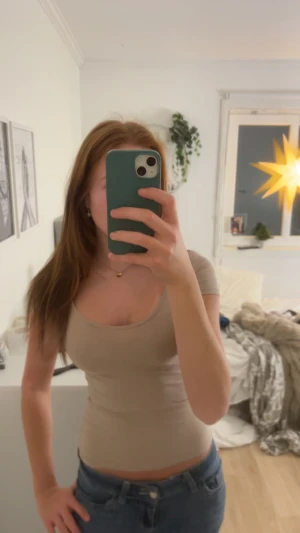 Beige tight kortärmad topp - Säljer en beige, tight och figurnära topp med korta ärmar och rundadad urringning. Mjuk och stretchig! Den är från HM i storlek XS, säljer då den inte används längre💗💗