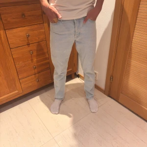 Ljusblå jeans från Jack & Jones 29/32 - Snygga ljusblå jeans från Jack & Jones i klassisk straight fit. Använda fåtal gånger! Min kille är 187 cm lång! Dem är i storlek 29/32 och är i en fin ljusblå färg! 