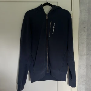 Mörkblå zip-kofta från Sail Racing  - Mörkblå hoodie från Sail Racing med dragkedja framtill och logga på bröstet. Har använts några gånger men super bra skick ändå. Det är inget fel på den eller nånting. Den har ganska tjockt material och varm inuti som är perfekt till vintern. Hör bara av er om ni har frågor. Pris kan diskuteras!! Det är även gratis frakt på den.