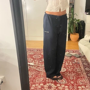 Marinblå Champion track/mjukisbyxor wide fit - Säljer ett par mörkblåa mjukisbyxor från Champion med broderad logga på sidan. Byxorna har en loose och wide passform, resår i midjan och är tillverkade i mjuk bomullsmix. Perfekta för en chill och avslappnad stil. Går att knyta i midjan!!