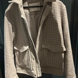 Grå rutig jacka från These Glory Days - Snygg grå jacka från These Glory Days i rutigt mönster. Jackan är super skön och varm och passar perfekt inför höst/vinterns. Super snygg att ha över t ex en skjorta. Passformen är normal. Kom gärna privat om du har frågor😄