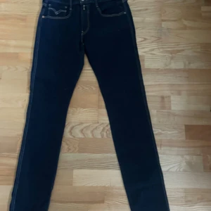 Replay Anbass mörkblå jeans, stl 33 - Snygga mörkblå Replay Anbass jeans i stretchigt Hyperflex-material. Klassisk femficksmodell med kontrastsömmar och normal passform. Perfekta för dig som gillar stilrena och bekväma jeans med modern känsla.