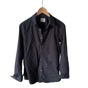 Svart skjorta från Acne Studios - Svart skjorta från Acne Studios med klassisk krage och knäppning framtill. skick 9/10 använd fåtal gånger. Ny oris på denna skjorta ligger på minst 2000kr.