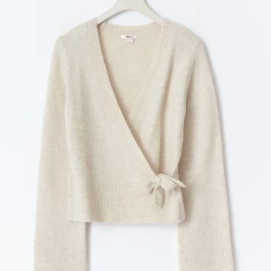 Beige omlottkofta från Gina Tricot - Supermysig beige omlottkofta från Gina Tricot med knyt i sidan och v-ringning. Koftan är stickad och har långa ärmar, perfekt för lager på lager. Köpt för några veckor sedan men passar inte rintigt som jag vill trots att jag tagit bort lappen. Endast testad! Passar som en S ungefär.